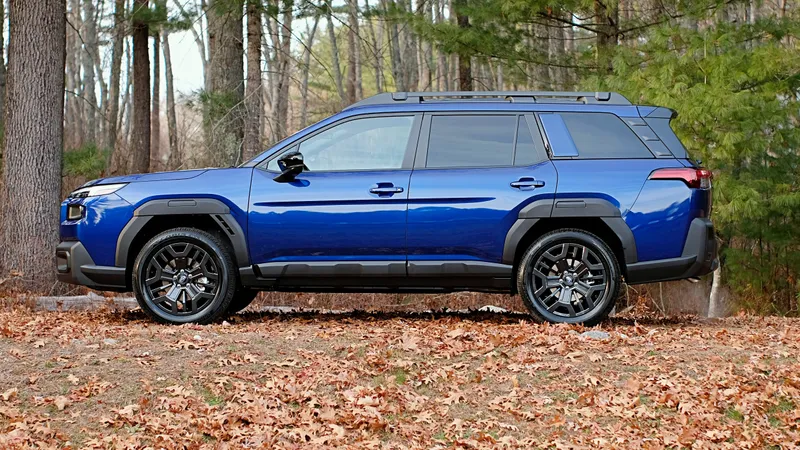 Blue 2027 Subaru Outback in autumn woods